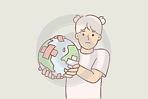 Little girl holding globe with band-aid, worrying about ECO issues and co2 carbon dioxide emissions