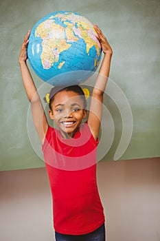 Little girl holding globe over head