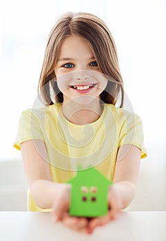 Little girl holding green paper house