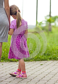 Little girl holding a hand of her mother. Family relations concept.