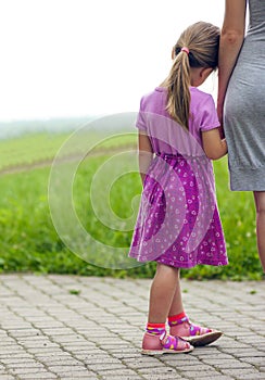 Little girl holding a hand of her mother. Family relations conce