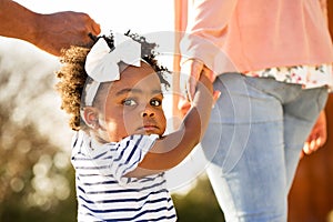 Little girl holding hands with her parents.