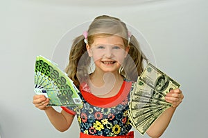 Little girl holding in hands a pack of dollars and Euro