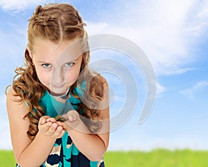 Little girl holding in hands a small turtle.