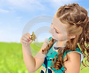 Little girl holding in hands a small turtle.