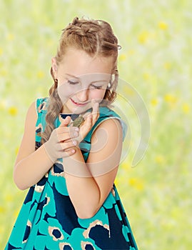 Little girl holding in hands a small turtle.