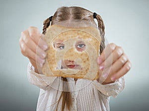 Little girl holding her face in front of a sad slice of bread