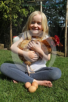 Little girl holding her pet chicken