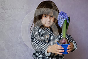 Little Girl holding hyacinth in flower pot