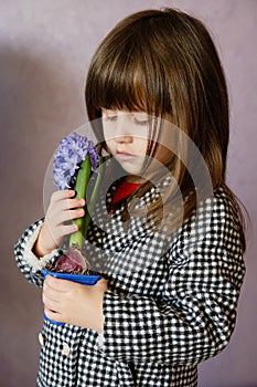 Little Girl holding hyacinth in flower pot