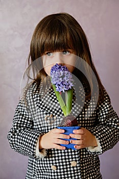 Little Girl holding hyacinth in flower pot