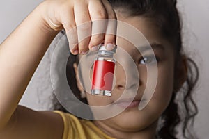 Little girl holding an injection vial in front of face mock-up series