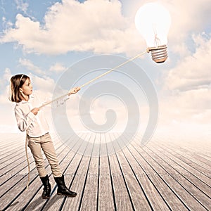 Little girl holding a light bulb with a rope