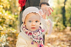 Little girl holding mothers hand. Spring toddler portrait.