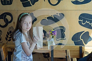 Little girl holding a paper bag with food in her hands