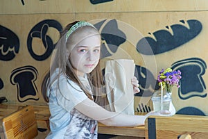 Little girl holding a paper bag with food in her hands