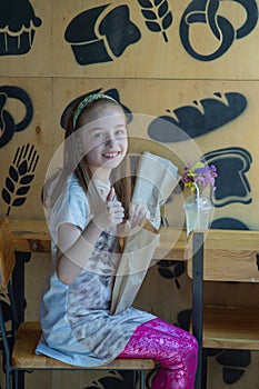 Little girl holding a paper bag with food in her hands