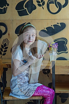 Little girl holding a paper bag with food in her hands