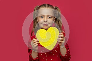 Little girl holding a paper heart.