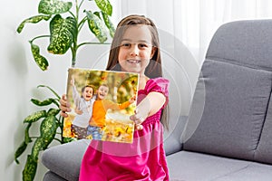 little girl holding photo canvas with autumn. Beautiful girl with canvas.