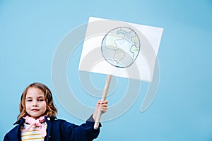 Little girl holding planet earth sign in protest against waste crisis
