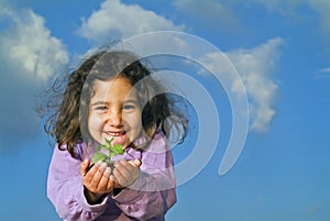 Little girl holding plant