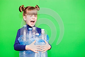 Little girl holding plastic bottles with close eyes and screams for help in protecting our planet from excessive use of plastic
