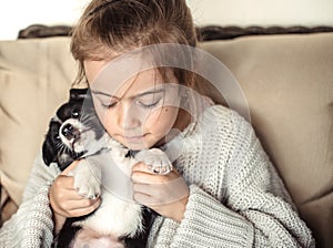 A little girl holding a puppy in her hands