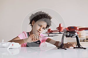 Little girl holding quadcopter. Child playing with drone at home.