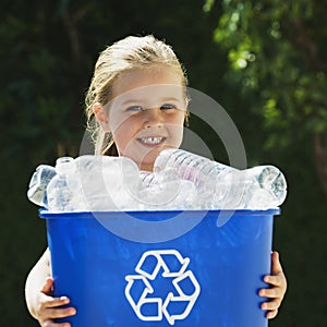 Little Girl Holding Recycling Bin photo