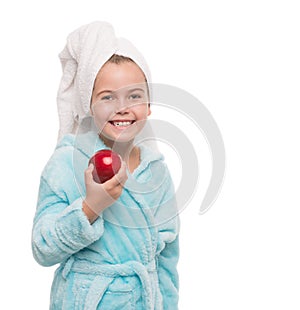 little girl holding red apple beside her cheek