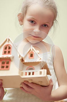 Little girl holding scale house model