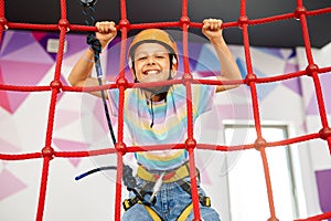 Little girl holding on to the ropes, zip line