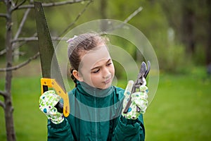 Little Girl Holding Tools In Garden At Spring Close-Up