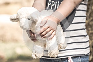 Little girl holding a toy sheep