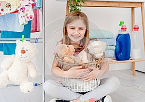 Little girl holding toys in washing basket