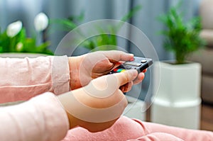 Little girl holding tv remote control at home