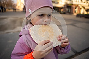 Little girl holding a typical traditional warm waffle or spa waffle in town Karlovy Vary or Carlsbad, Czech Republic photo