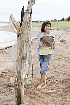 Little girl holding up wooden sign