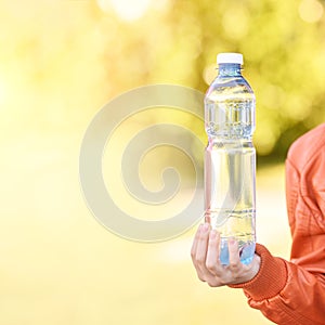 Little girl holding water bottle. Outdoor training. Thirsty