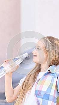 Little girl holding water bottle. Outdoor training. Thirsty. Glass drink