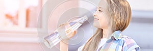 Little girl holding water bottle. Outdoor training. Thirsty. Glass drink