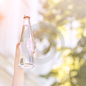 Little girl holding water bottle. Outdoor training. Thirsty. Glass drink