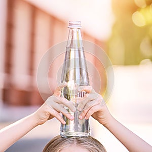 Little girl holding water bottle. Outdoor training. Thirsty. Glass drink