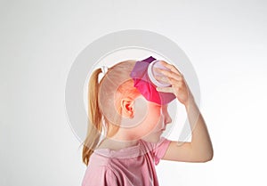 A little girl holds a bag of ice cold against her head. The concept of applying a cold compress to bruises and bumps on