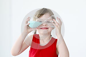 Little girl holds blue hourglass in her hands