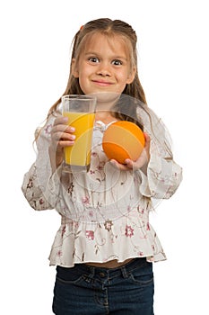 Little Girl Holds a Glass with an Orange Juice with One Hand and