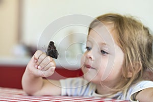 Little girl holds on the hand the Aglais io butterfly and watches for him