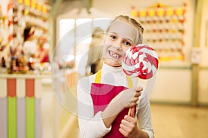 Little girl holds handmade sugar caramel on stick