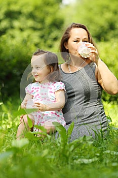 Little girl holds milk and her mother drinks milk